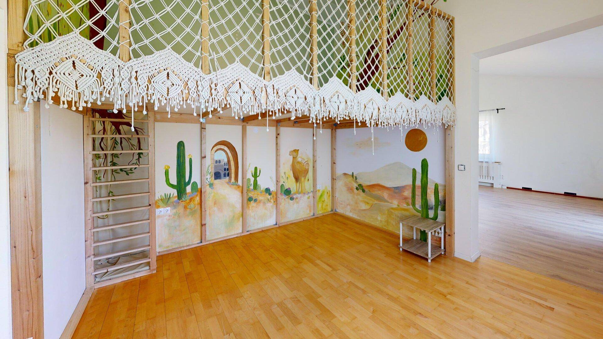 Spielzimmer mit kreativer Wandmalerei, Hochbett und hellem Holzboden für Kinder.
