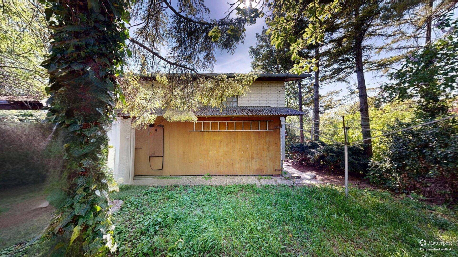 Rückseite des Hauses mit Gartenbereich und altem Baumbestand.
