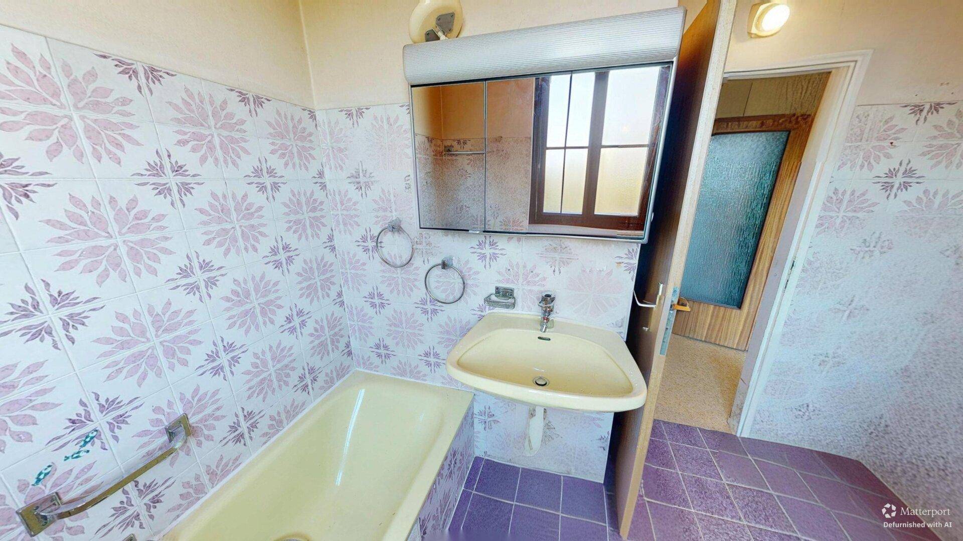 Badezimmer mit Waschbecken, Badewanne und Spiegelschrank, gefliest im Retro-Stil.