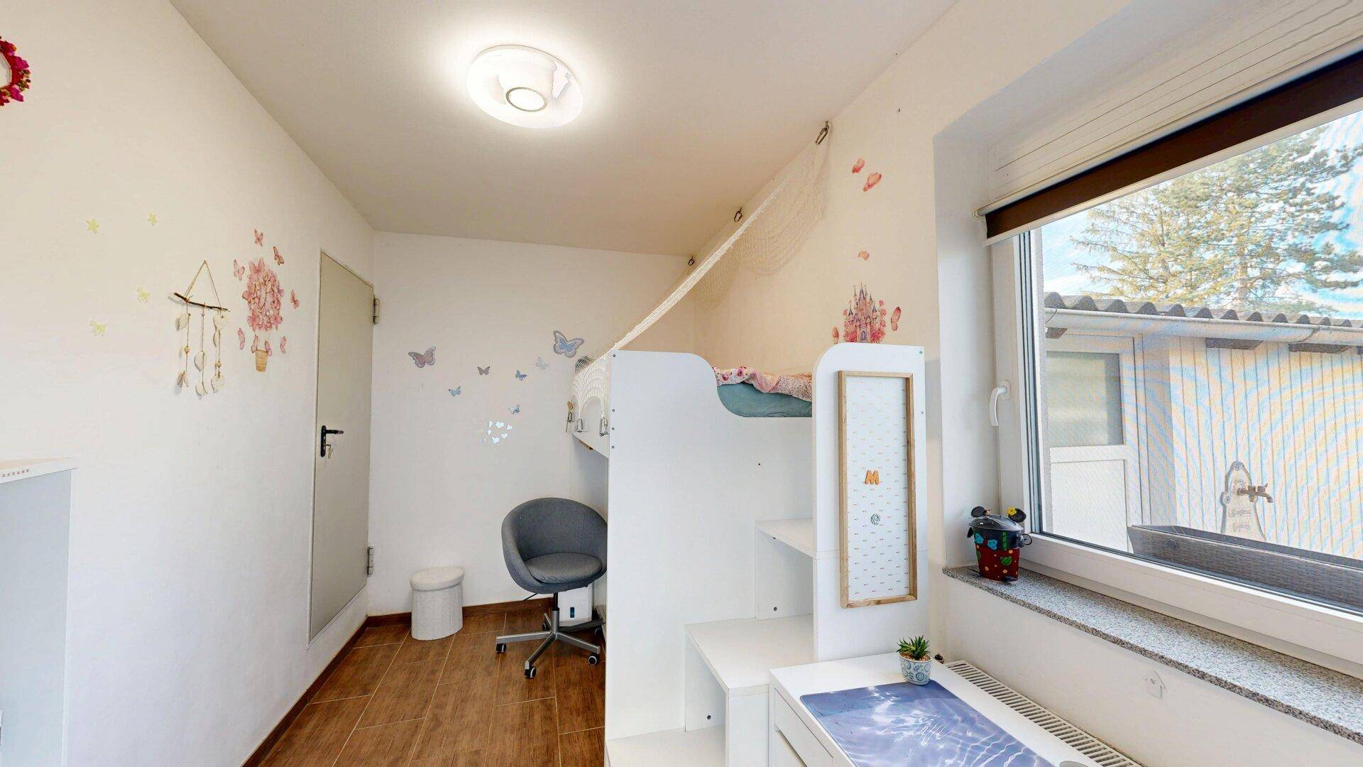 Kinderzimmer mit Hochbett, Schreibtisch und farbenfrohen Wanddekorationen, ideal für Kinder.