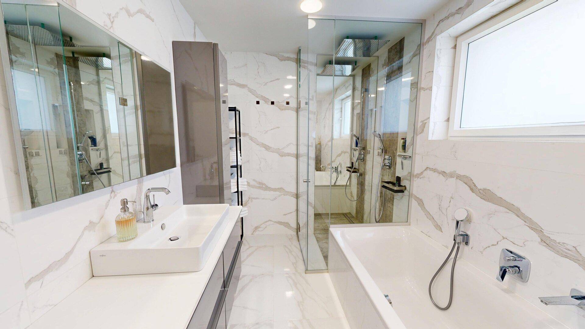 Modernes Badezimmer mit großen Marmorfliesen, Doppelwaschbecken und begehbarer Dusche.