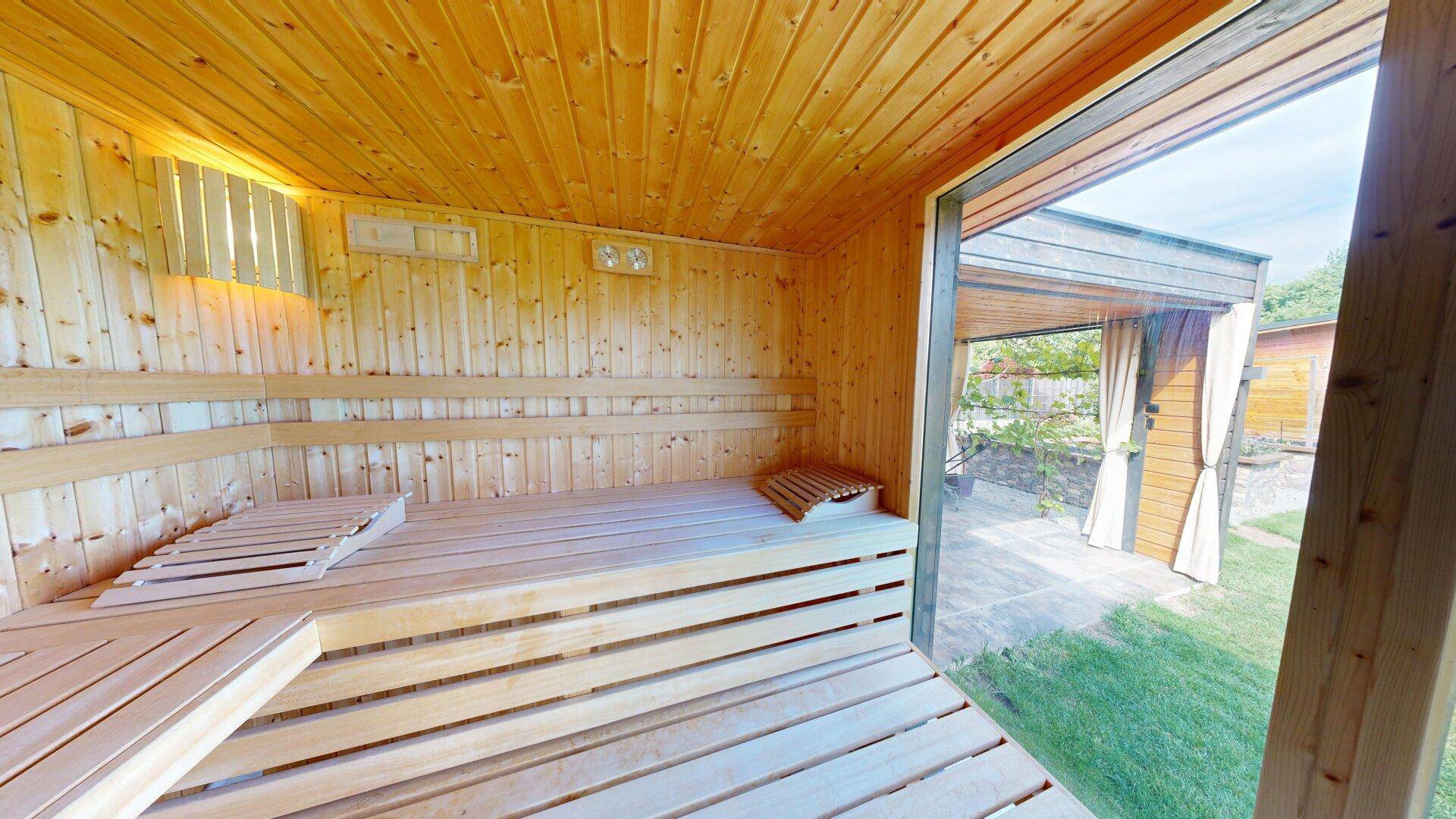 Helle Holzsauna mit Glasfront und Blick auf den Garten, ideal zur Entspannung.