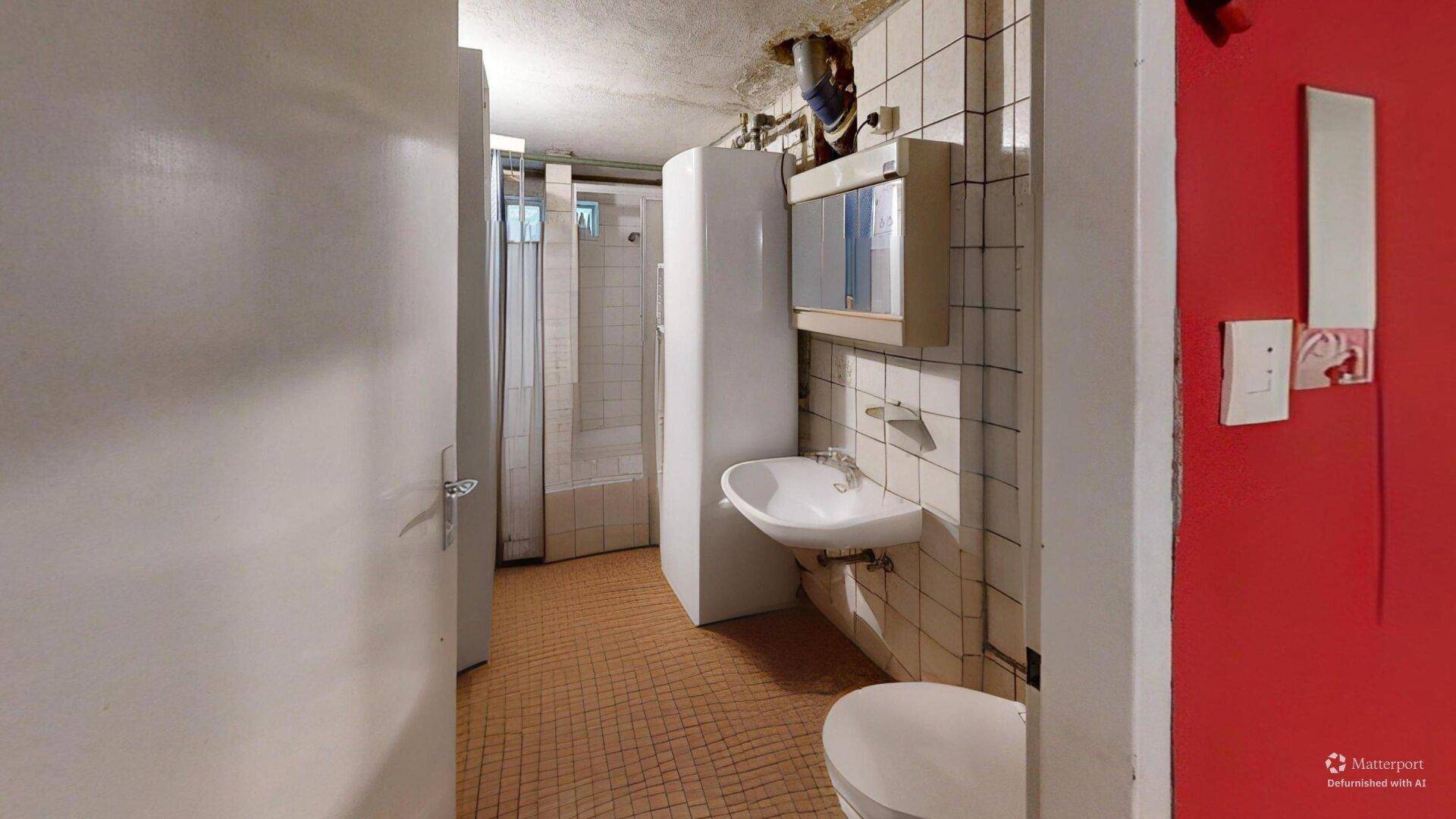 Funktionales Badezimmer mit Dusche, Waschbecken und WC, gefliest und in originalem Zustand, bereit zur Modernisierung.
