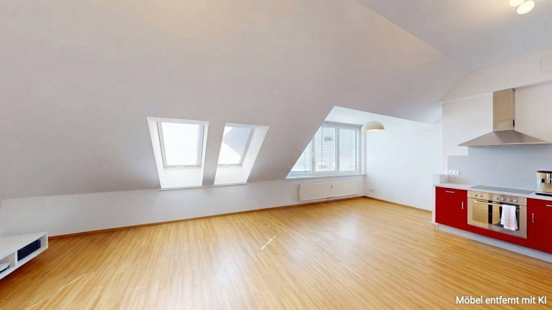 Geräumiger Wohnbereich mit moderner roter Küche, Dachschrägen und viel Tageslicht.