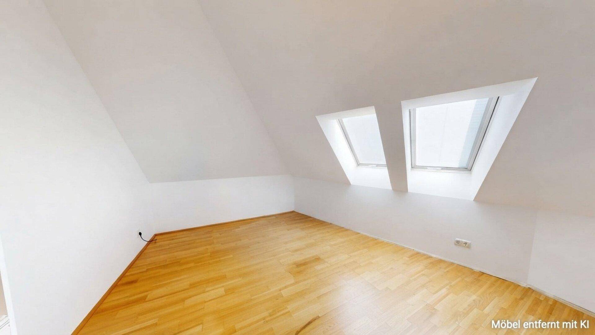 Helles Schlafzimmer im Dachgeschoss mit Holzboden und zwei Dachfenstern für natürliches Licht.