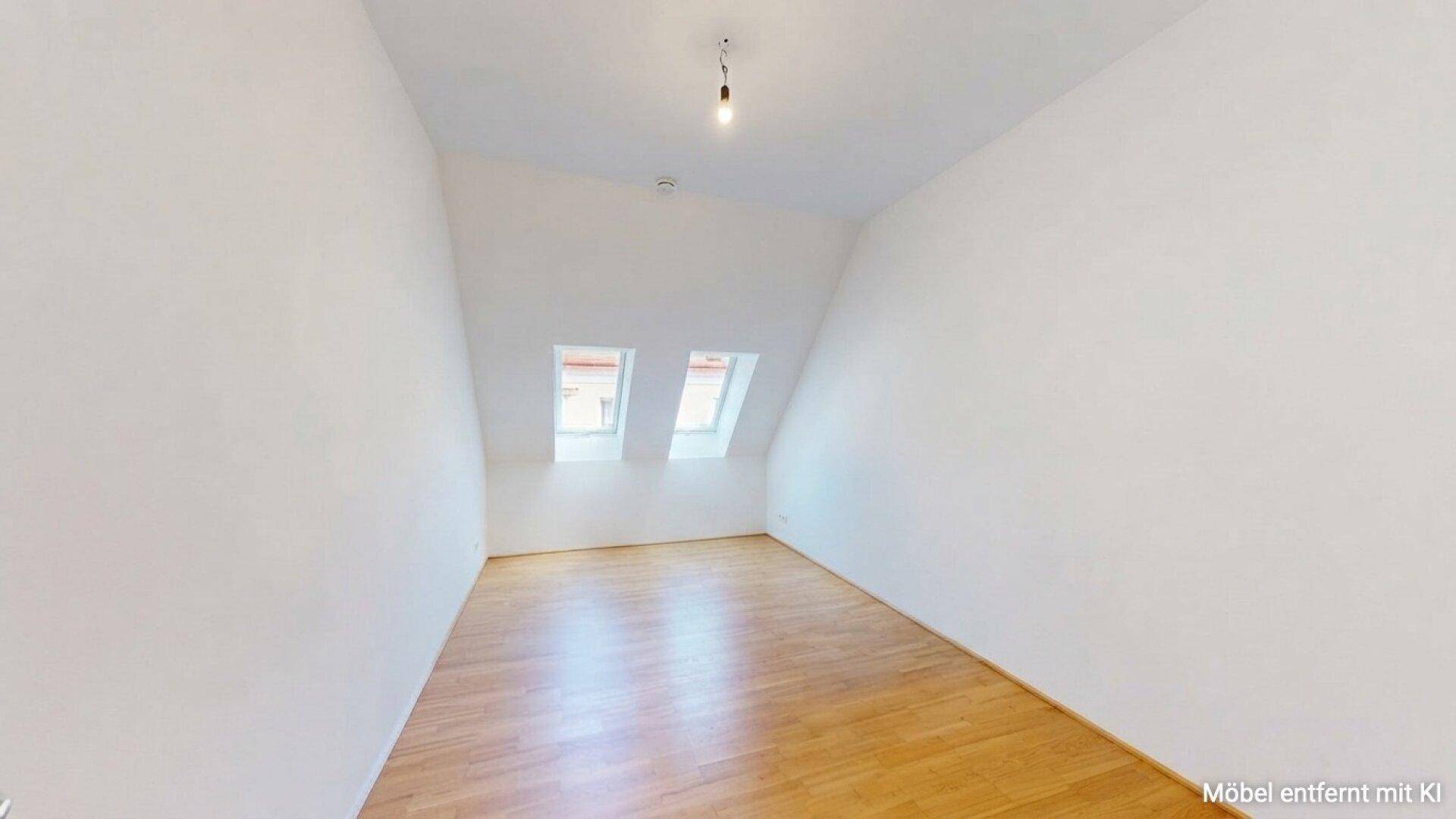 Geräumiges Schlafzimmer mit Dachschrägen, hellem Holzboden und Oberlichtfenstern.