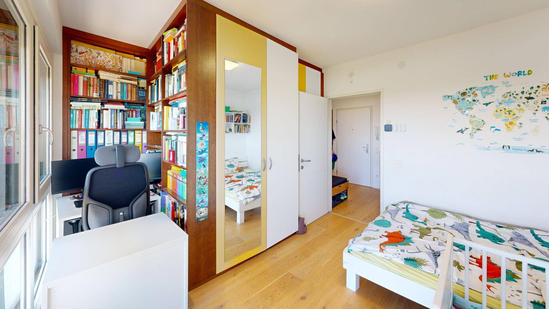 Kinderzimmer mit Schreibtisch, Bücherregal und Bett, hell und funktional als Büro genutzt.
