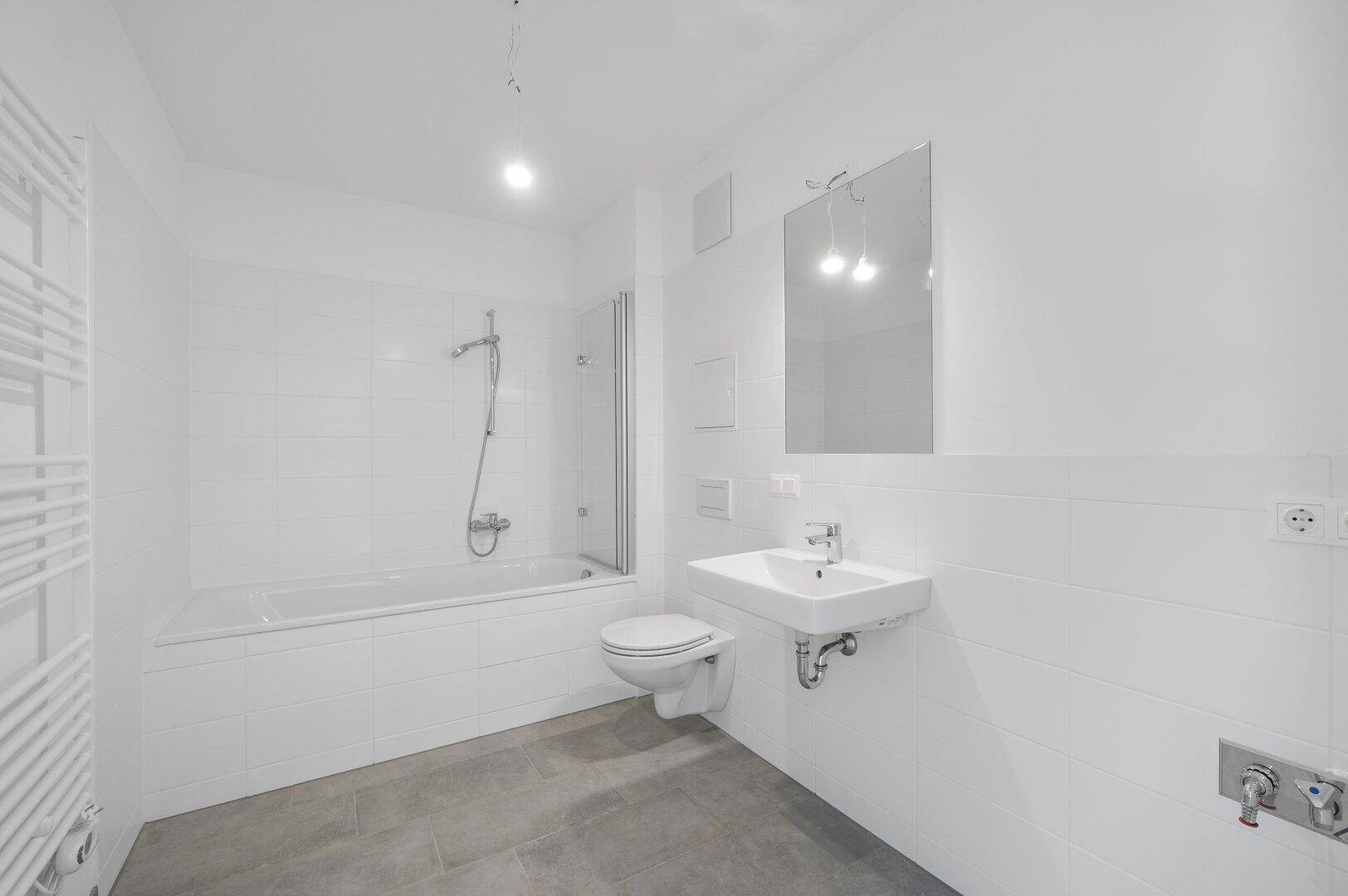 Modernes Badezimmer mit Badewanne, Dusche, Waschbecken und Wand-WC.