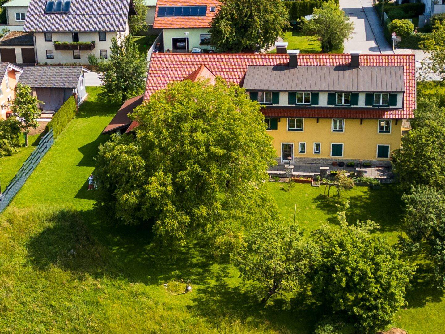 Luftaufnahme des Anwesens mit weitläufigem grünen Garten, umgeben von Bäumen und ländlicher Umgebung.