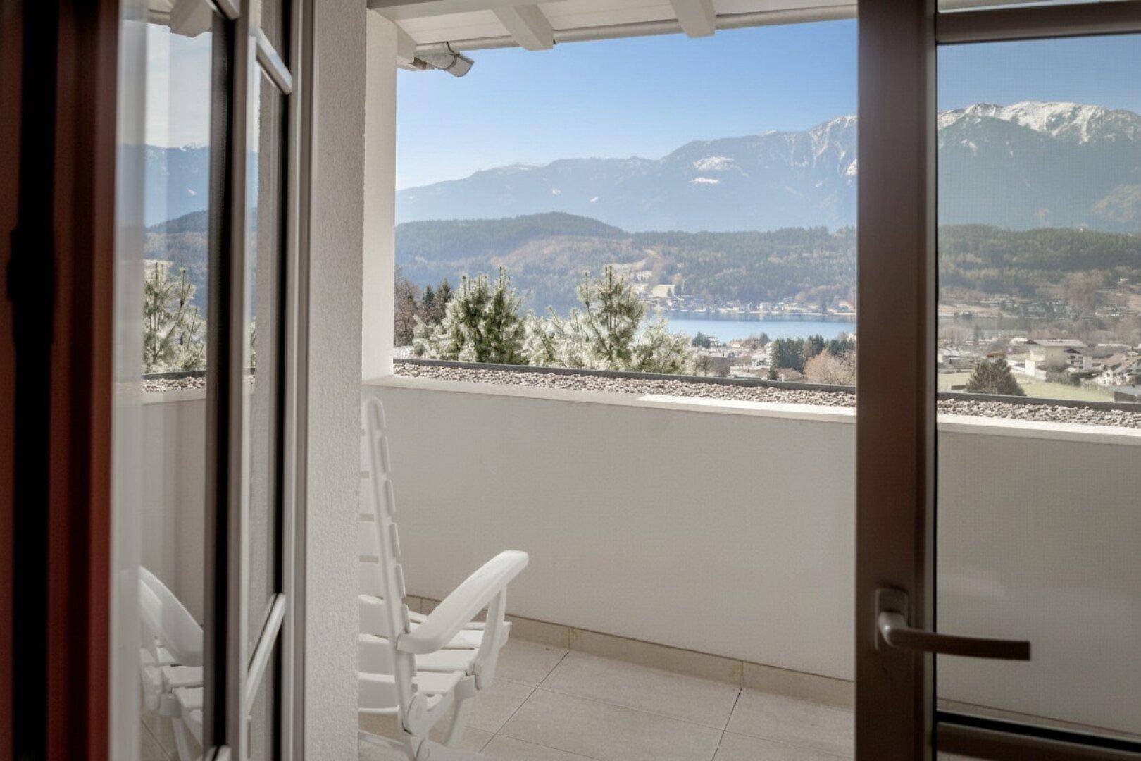 Privater Balkon mit Sitzgelegenheit und weitem Blick auf den See und die Berge.