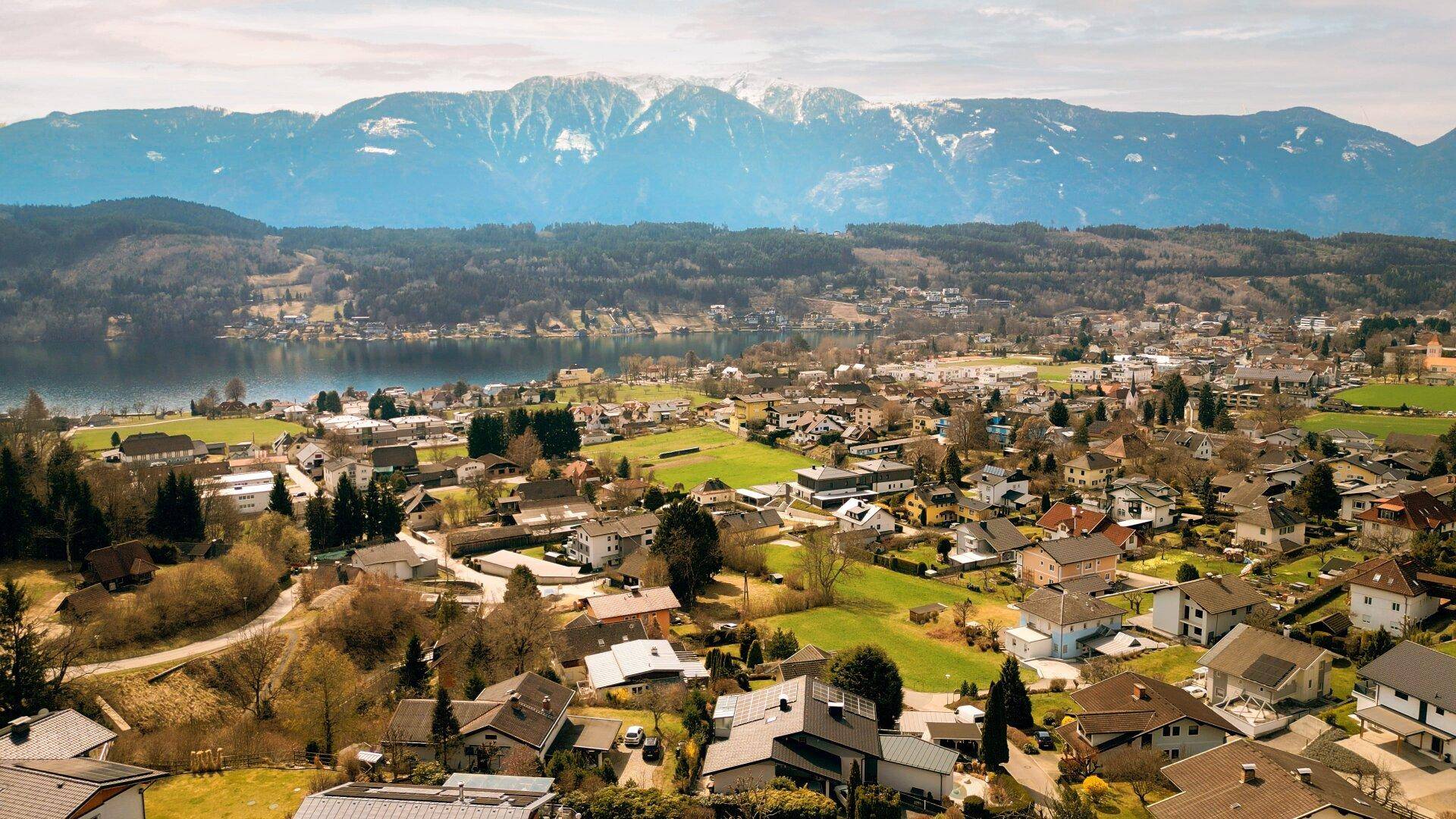 Panoramablick auf die malerische Stadt, den See und die majestätischen Berge im Hintergrund.