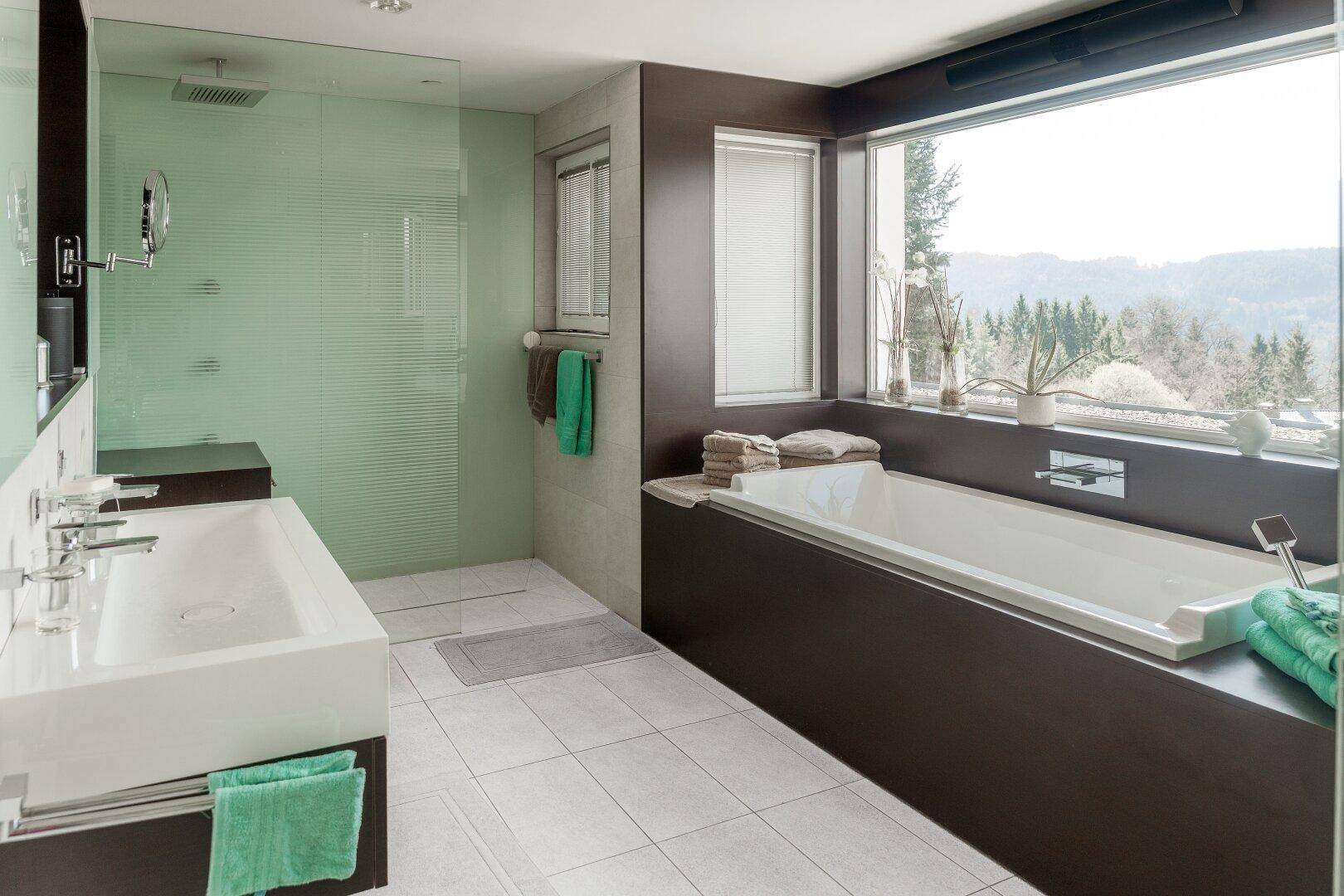 Modernes Badezimmer mit großer Badewanne, Doppelwaschbecken und bodengleicher Dusche.