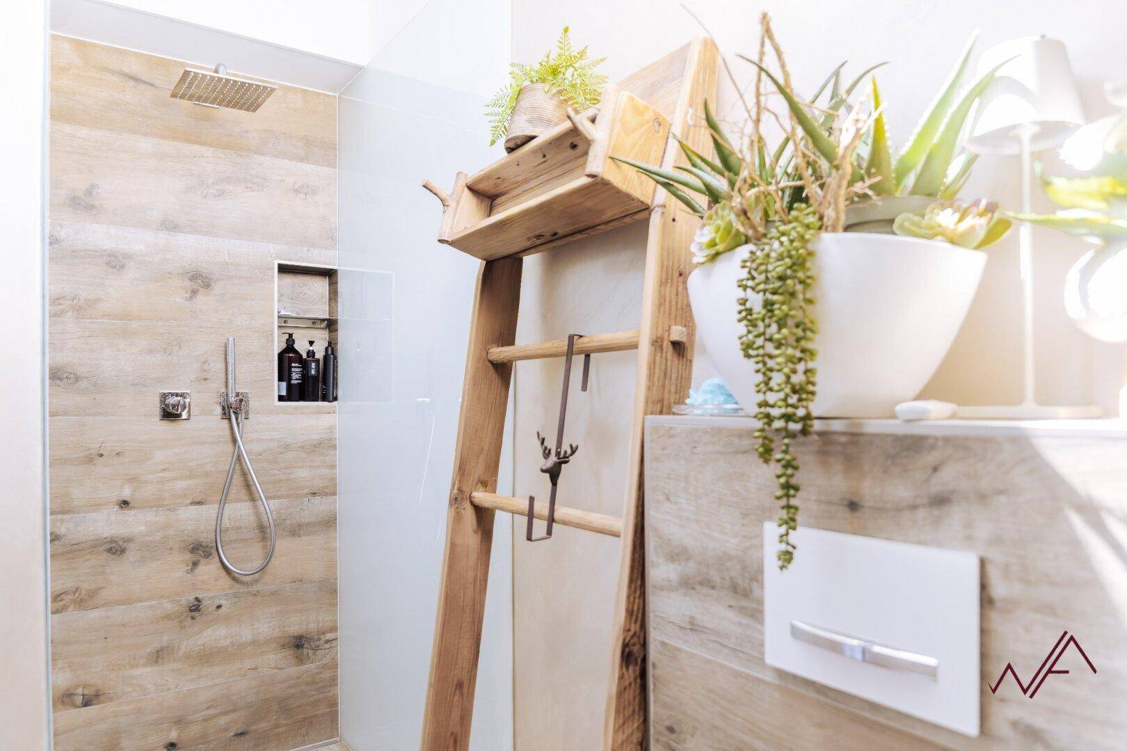 Modernes Badezimmer mit ebenerdiger Dusche, Holzoptik-Fliesen und stilvoller Dekoration.
