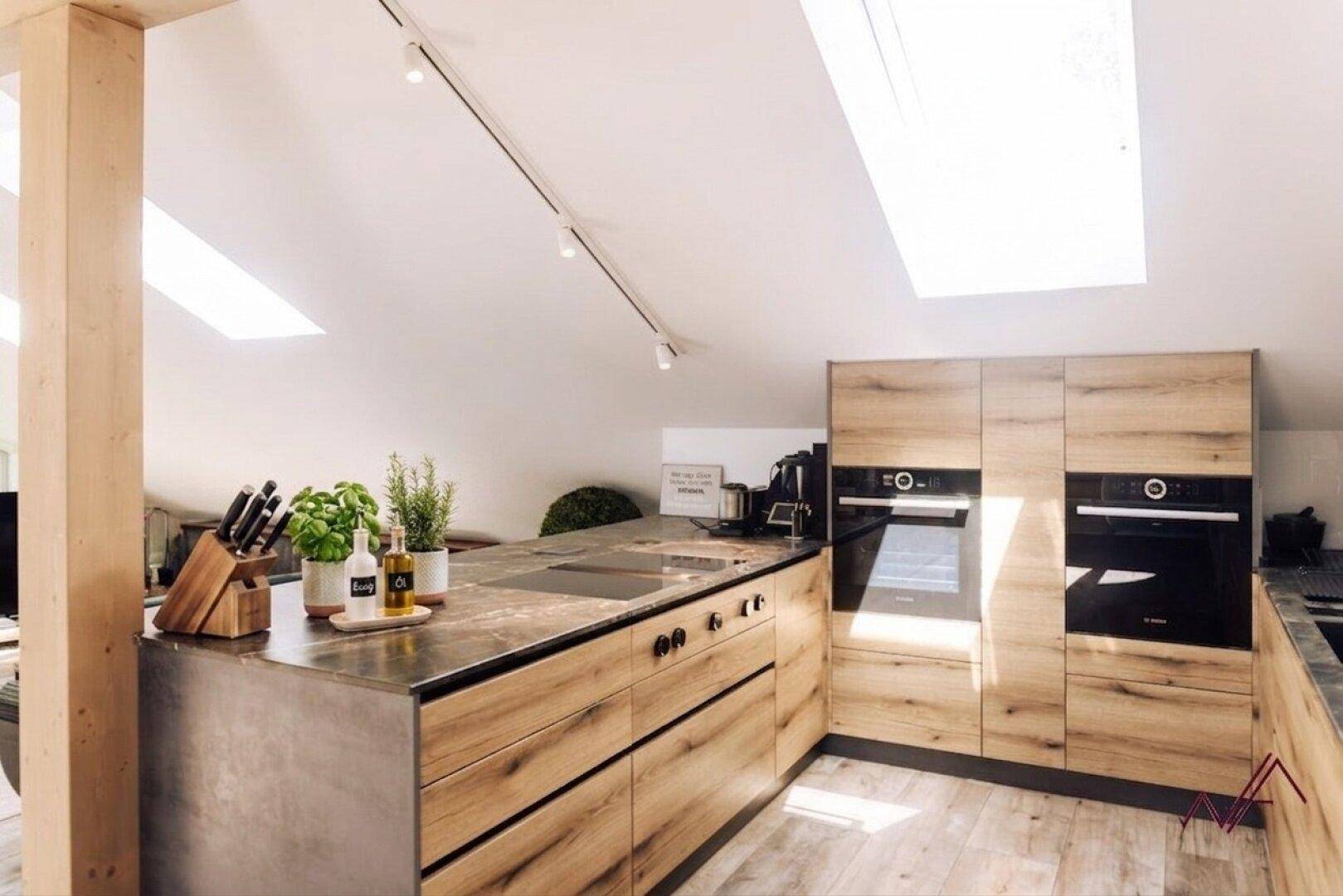 Moderne Küche im Dachgeschoss mit Holzelementen, Einbaugeräten und Dachfenstern für viel Licht.