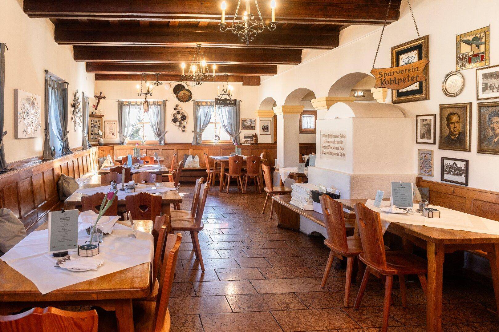 Geräumiger traditioneller Speisesaal mit Holztäfelung, Holzbalkendecke und vielen Tischen.