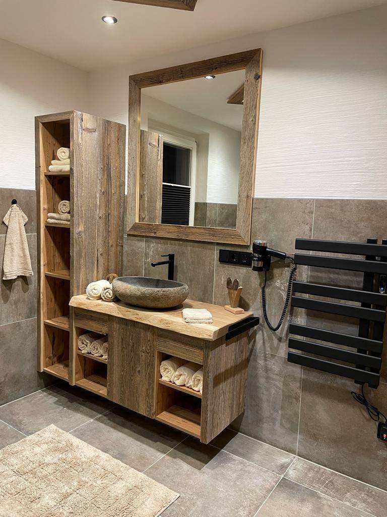 Stilvolles Badezimmer mit Holzwaschtisch, Aufsatzwaschbecken und beheiztem Handtuchhalter.