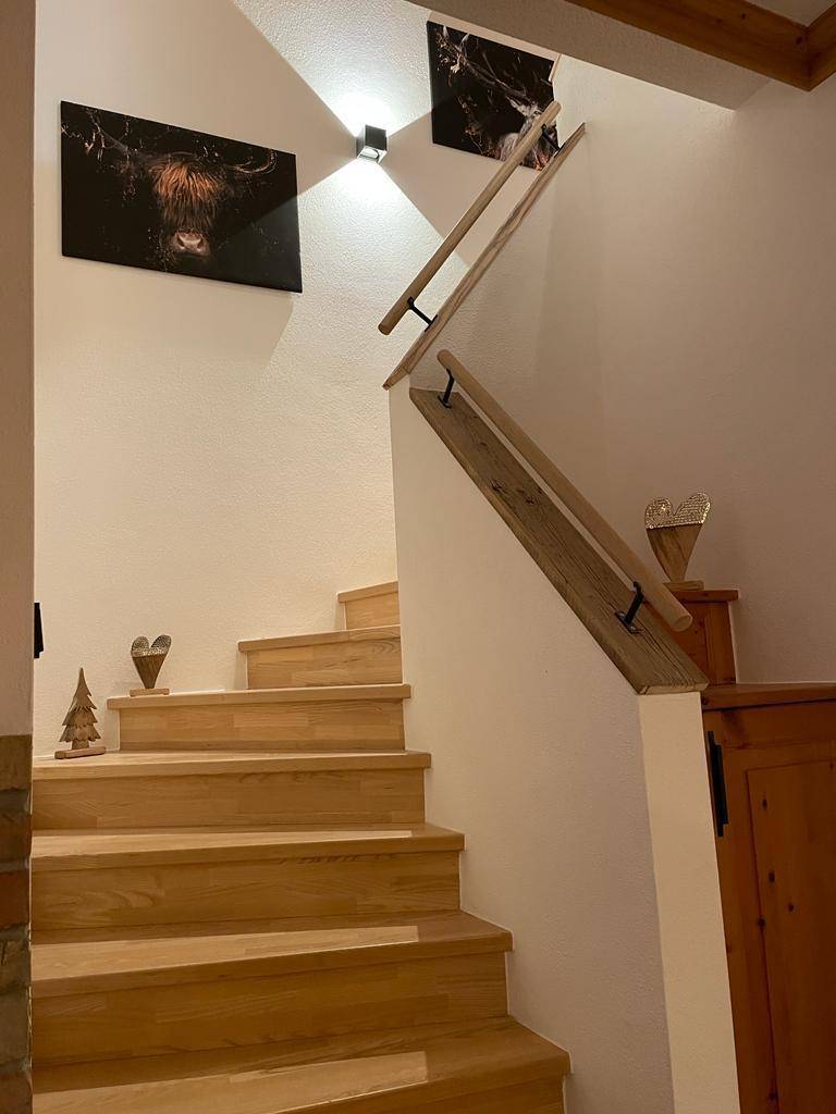 Helle Holztreppe mit schlichten Geländern, die zu den oberen Etagen führt.