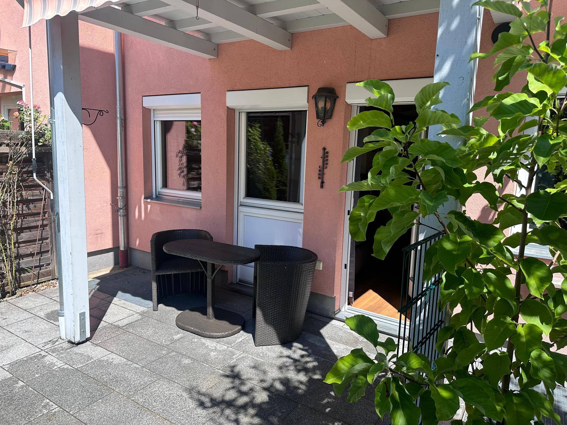 Gemütliche Terrasse mit Sitzgelegenheiten und Markise, ideal für entspannte Stunden im Freien.