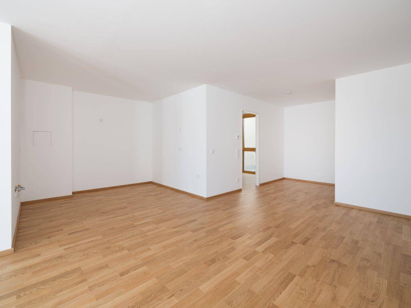 Geräumiger, heller Wohnbereich mit elegantem Parkettboden und offener Gestaltung, bereit zur individuellen Einrichtung.