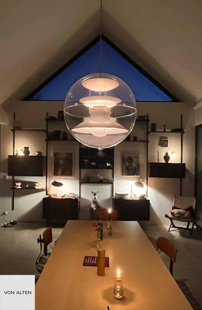 Gemütlicher Essbereich am Abend mit Kerzenlicht und einer modernen Hängelampe.