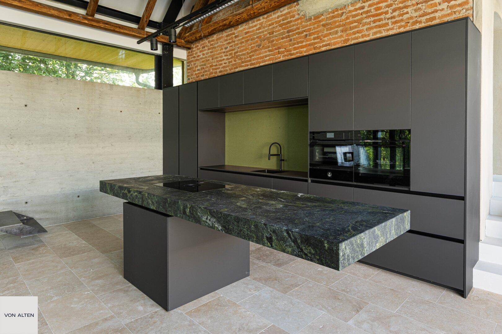 Elegante moderne Küche mit dunklen Schränken, Naturstein-Arbeitsplatte und integrierten Geräten.