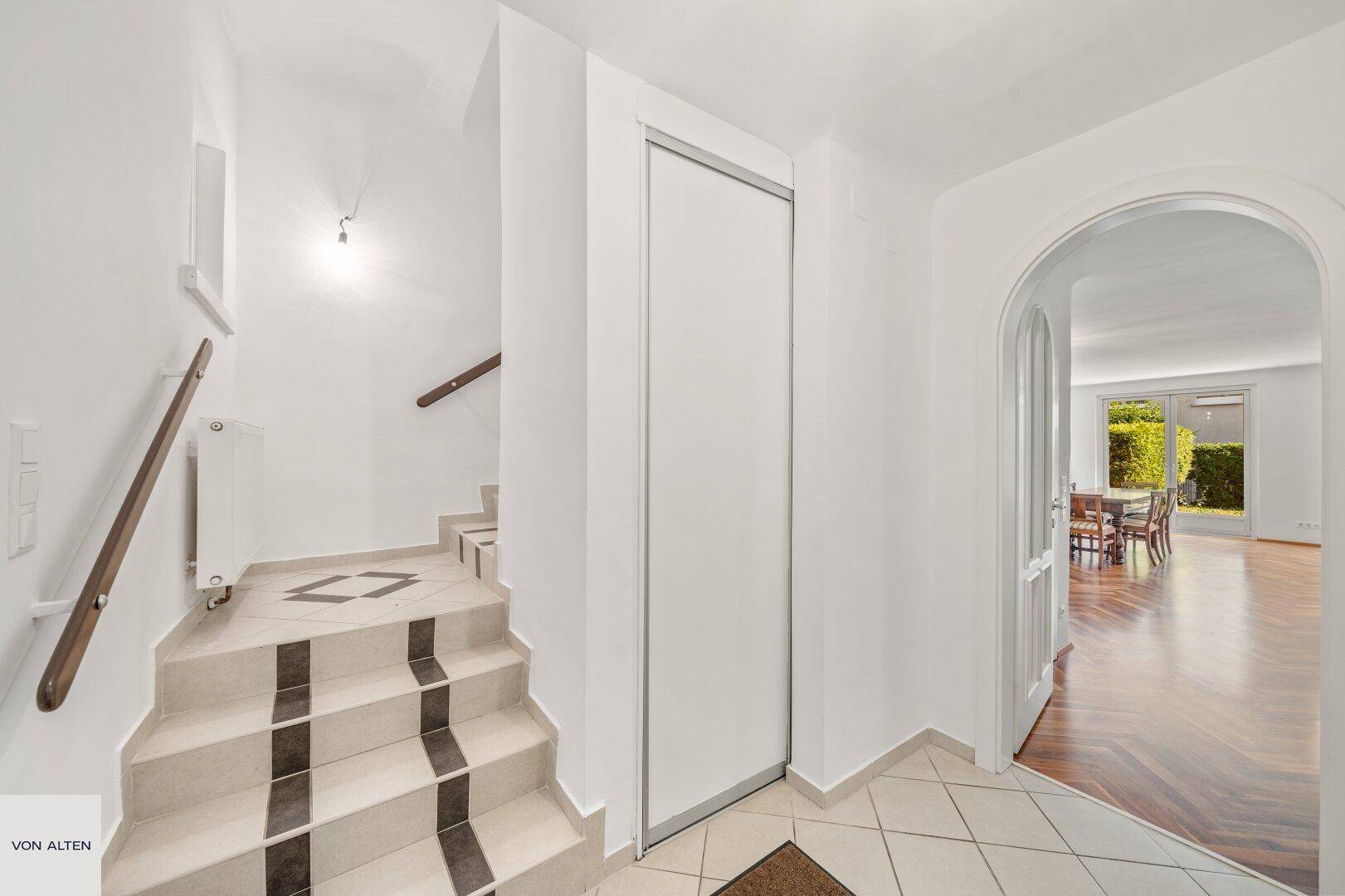Eingangsbereich mit gefliester Treppe, Einbauschrank und Zugang zu weiteren Räumen.