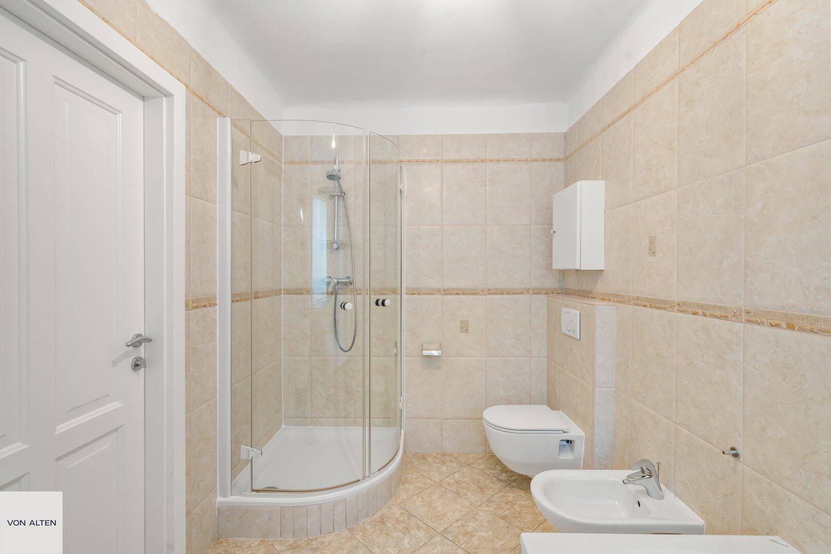 Badezimmer mit Duschkabine, Toilette und Bidet.