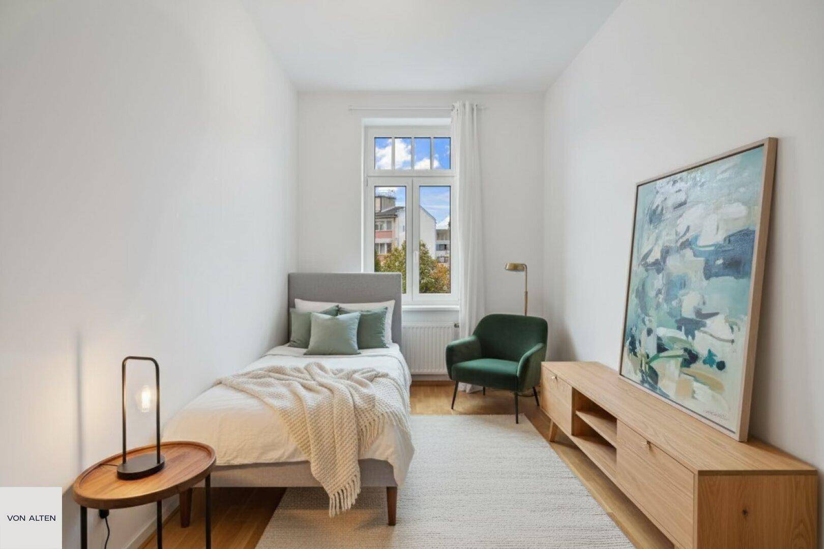 Gemütliches Schlafzimmer mit Einzelbett, Holzboden und einem Fenster, das einen Blick ins Grüne bietet.