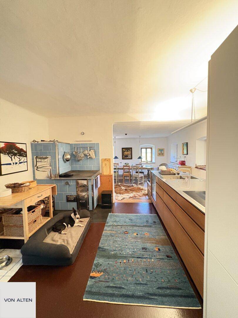 Traditionelle Küche mit blau gefliestem Kachelofen und modernem Küchenblock.