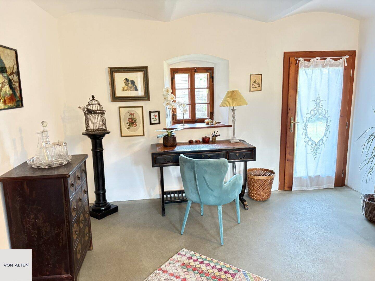 Helles Arbeitszimmer mit gewölbter Decke, Holztüren und einem Schreibtisch mit Blick nach draußen.