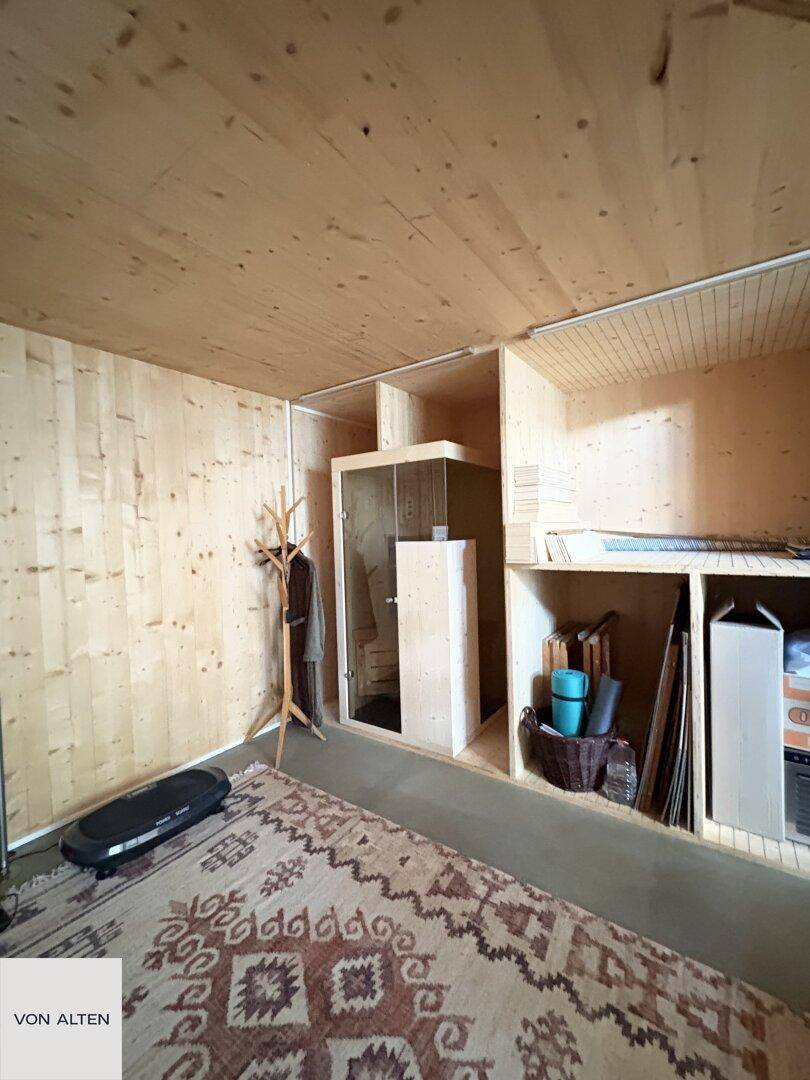 Holzverkleideter Raum mit Teppich, Stauraum und einer integrierten Duschkabine.