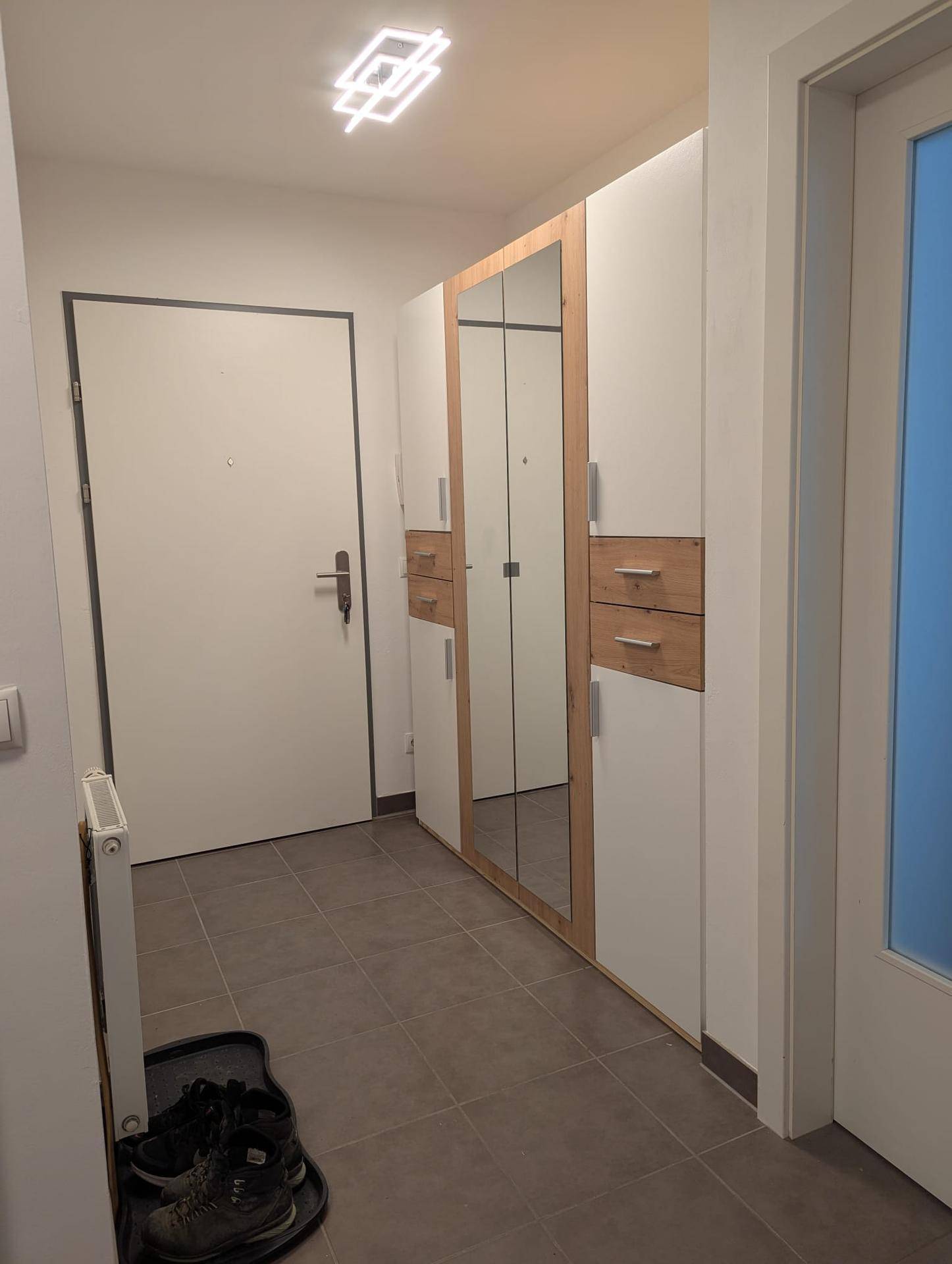 Eingangsbereich mit praktischem Spiegelschrank und Fliesenboden.