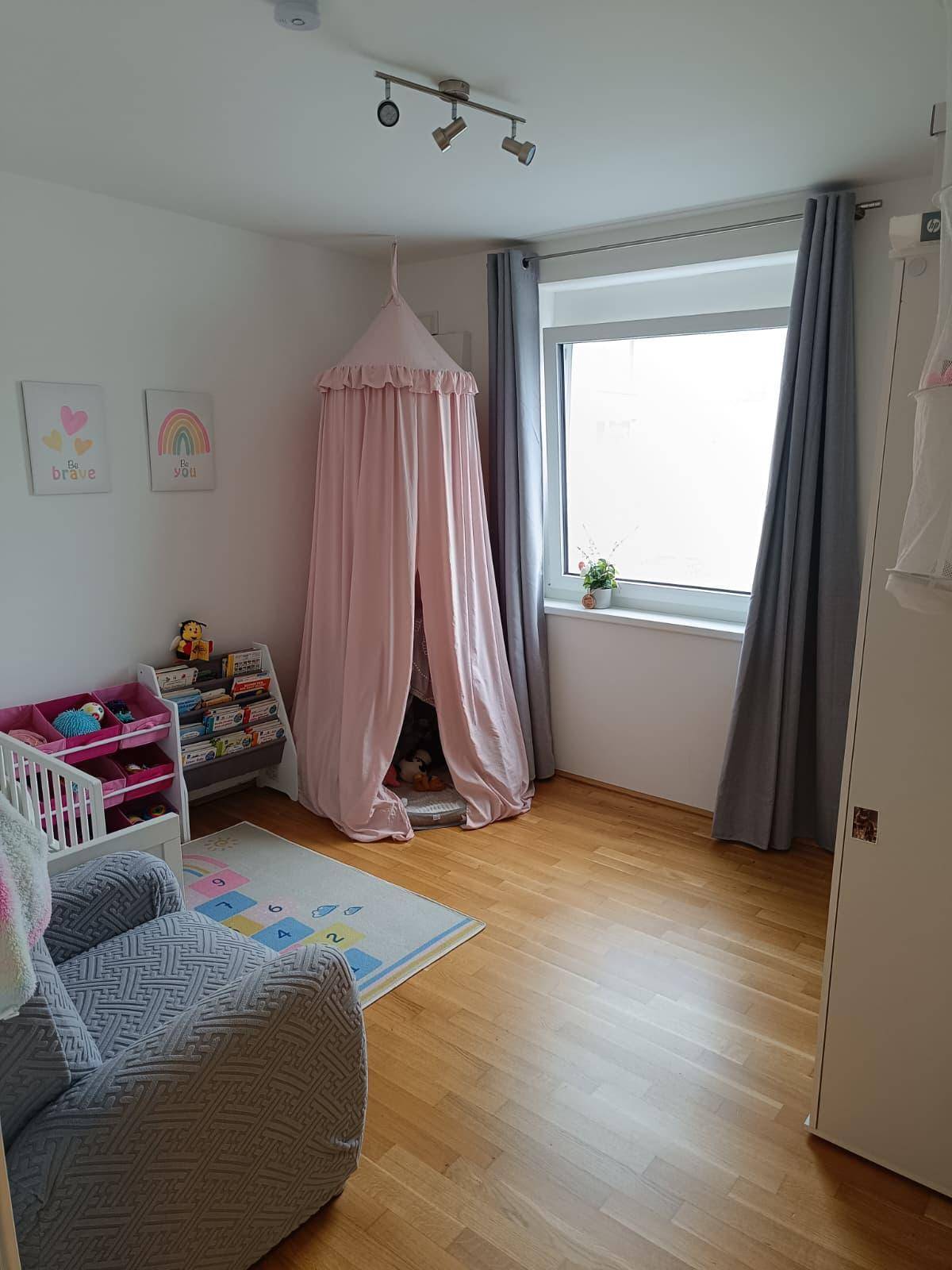 Kinderzimmer mit Holzboden, einem Fenster und spielerischer Dekoration, ideal für kleine Kinder.