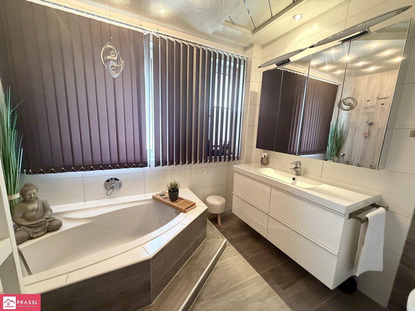 Modernes Badezimmer mit Eckbadewanne, großem Waschtisch und Spiegelschrank.