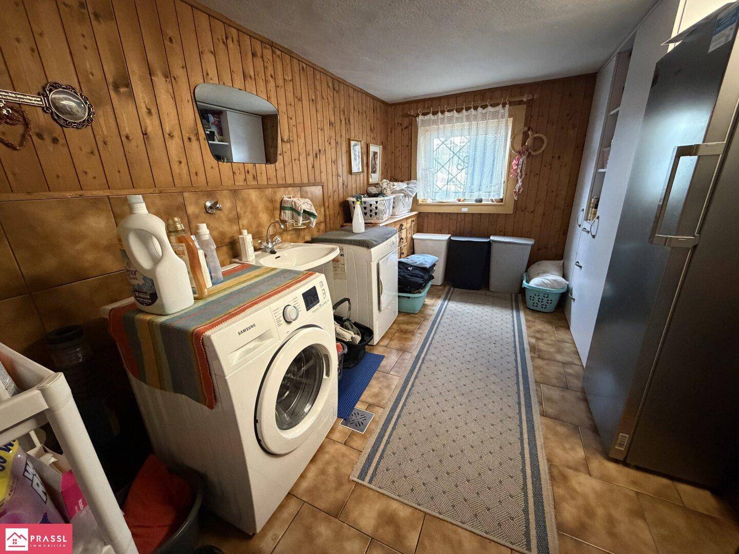 Praktischer Hauswirtschaftsraum mit Waschmaschine, Trockner und viel Stauraum.