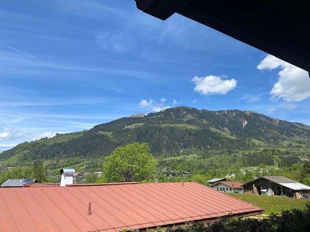 Weitläufiger Blick auf bewaldete Hügel und die ländliche Umgebung unter einem klaren blauen Himmel.