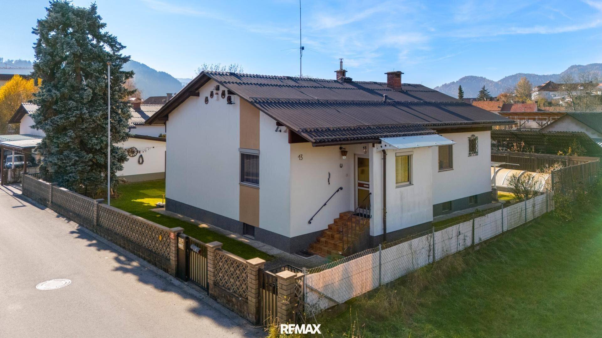 Vorderansicht des Hauses von der Straße mit Eingangsbereich, kleinem Vorgarten und Zaun.
