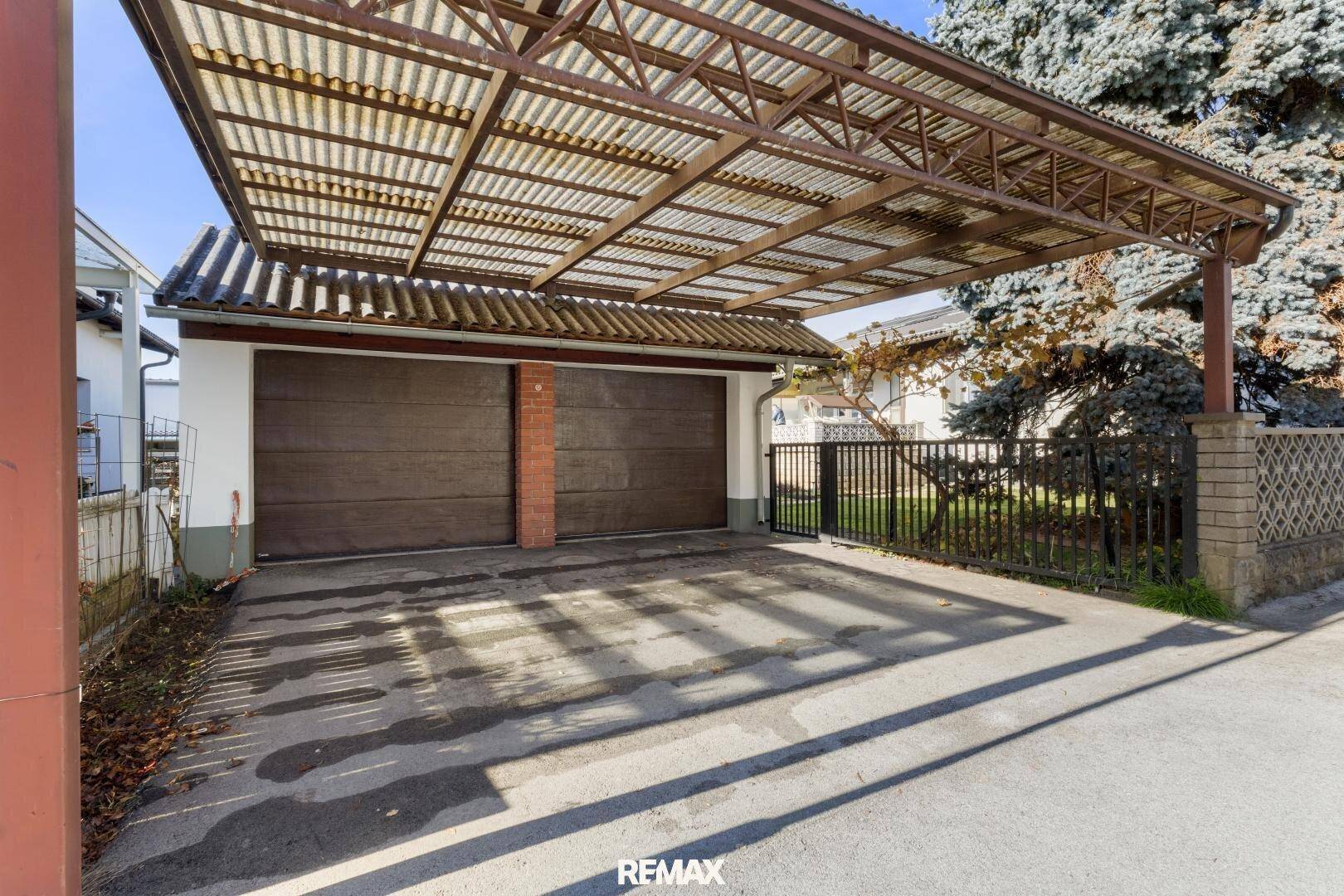 Doppelgarage mit vorgelagertem Carport, bietet geschützten Parkraum für Fahrzeuge.
