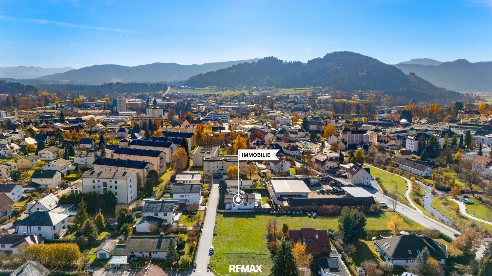 Weitläufige Luftaufnahme der Immobilie im Kontext der umliegenden Bebauung und Landschaft.
