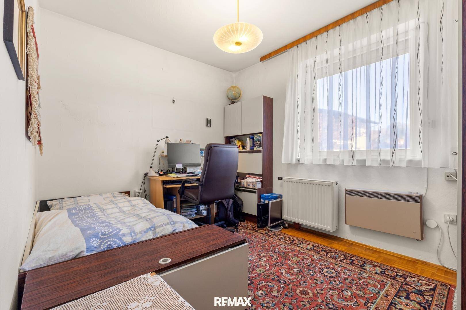 Helles Zimmer mit Einzelbett, Schreibtisch und Fenster, ideal als Gäste- oder Arbeitszimmer.
