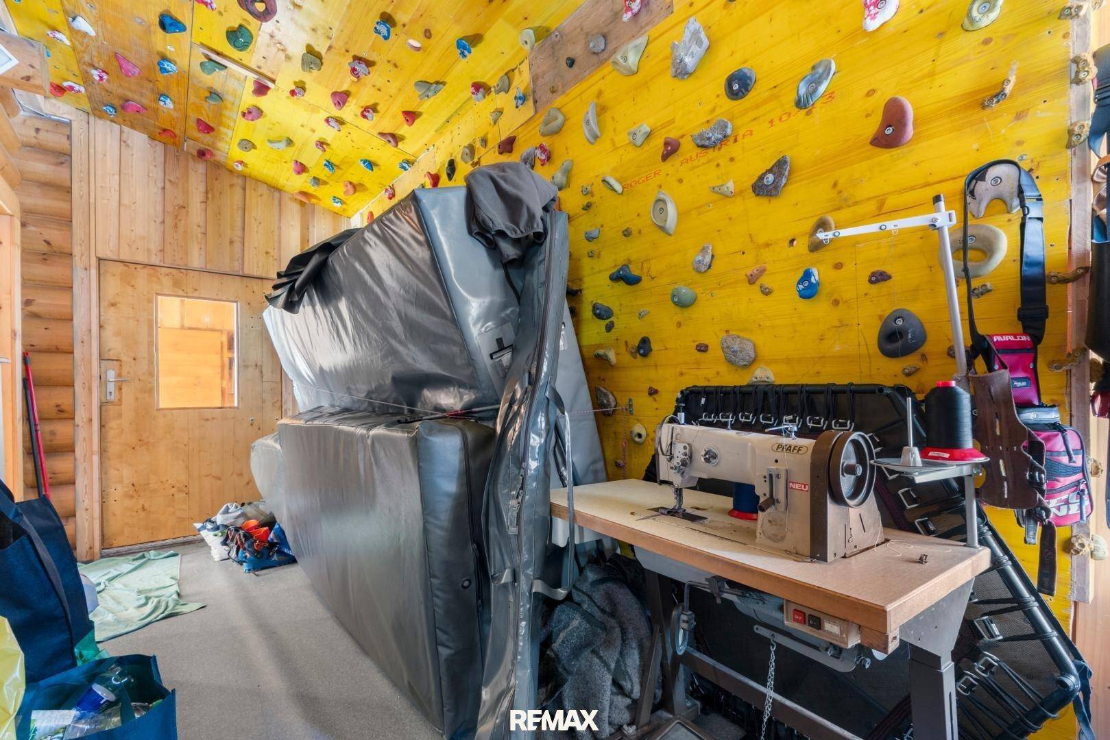 Sportraum mit Kletterwand, Nähmaschine und Matten für verschiedene Aktivitäten.