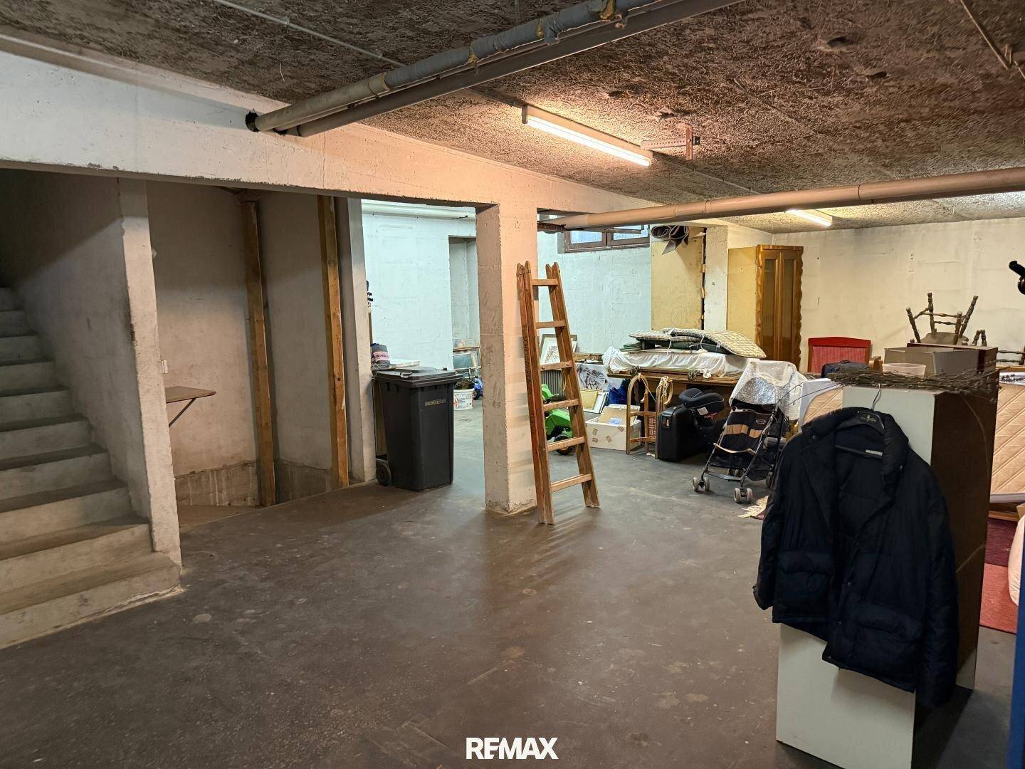 Geräumiger Kellerbereich mit Treppe und verschiedenen Gegenständen, der viel Stauraum bietet.