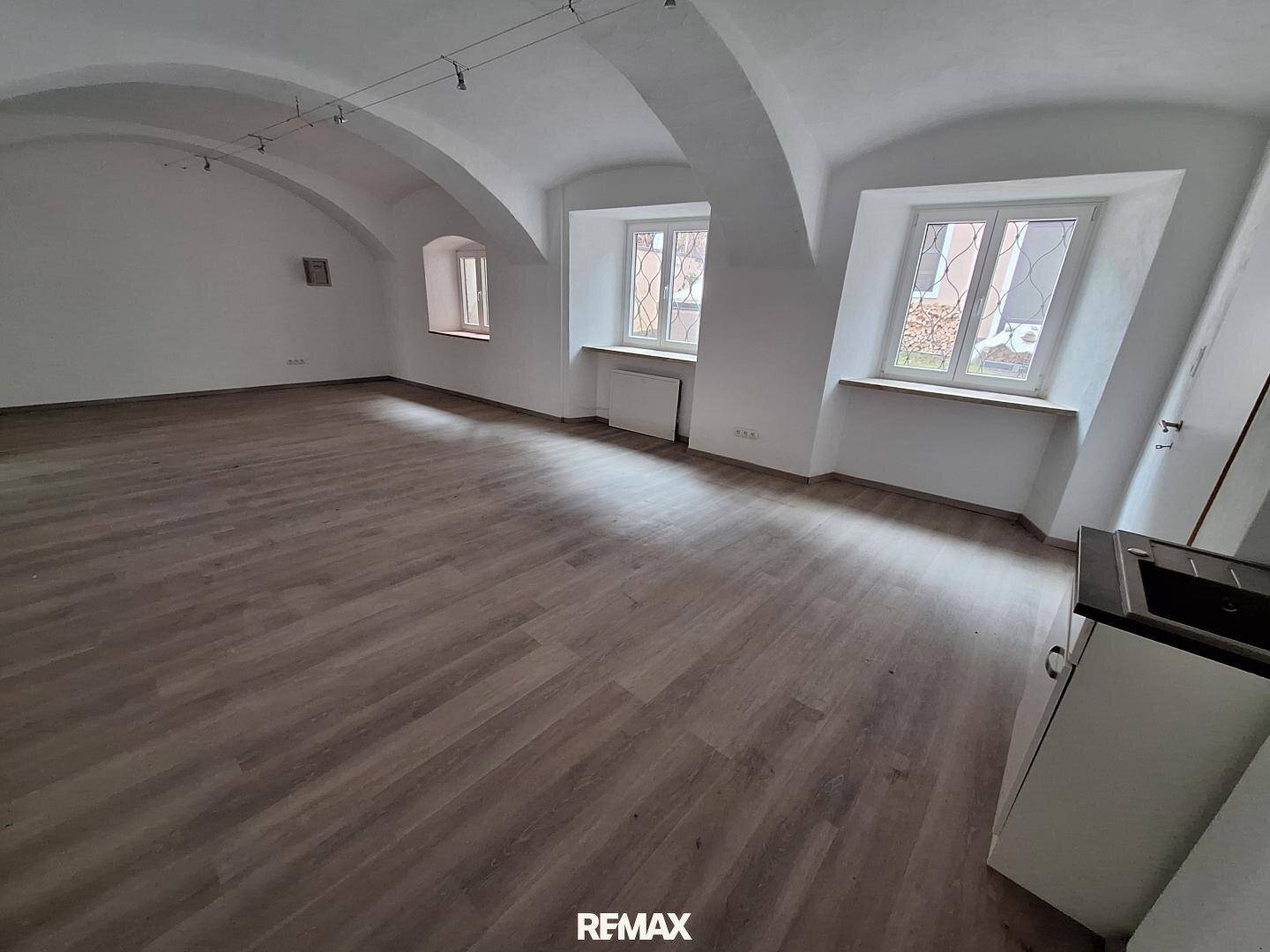 Heller, leerer Raum mit Gewölbedecke und Holzboden, bereit für individuelle Gestaltung.