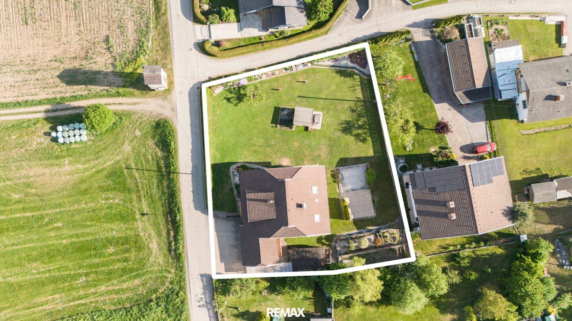 Luftaufnahme des Anwesens mit großem Garten und umliegender Landschaft.