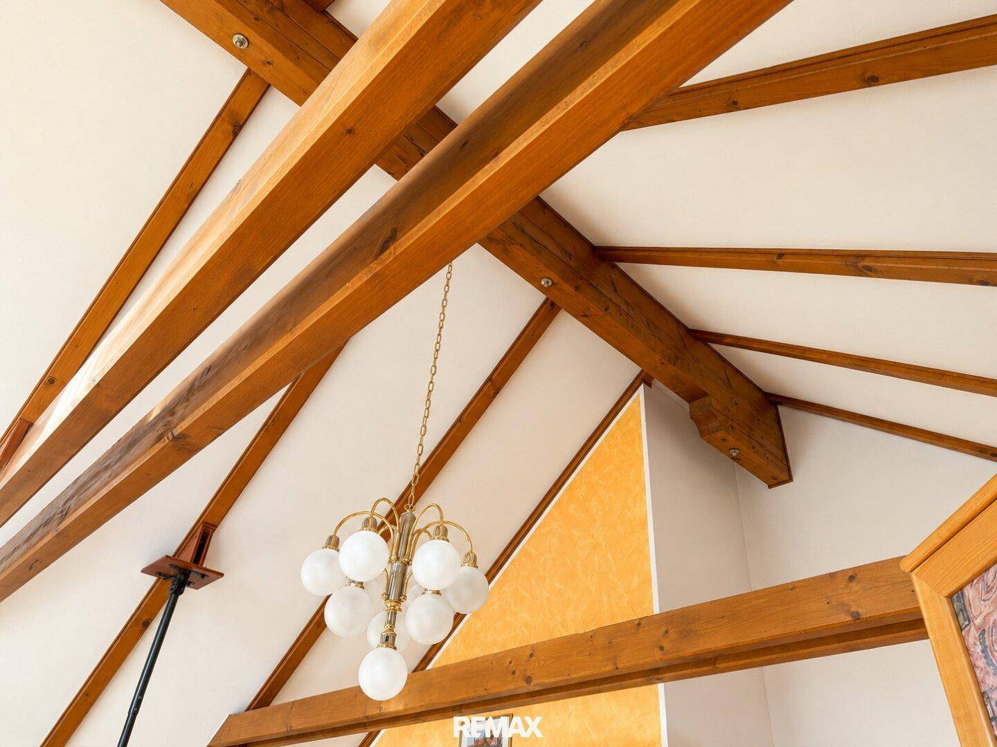 Detailaufnahme der Holzbalkenkonstruktion an der Decke, die rustikalen Charme verleiht.