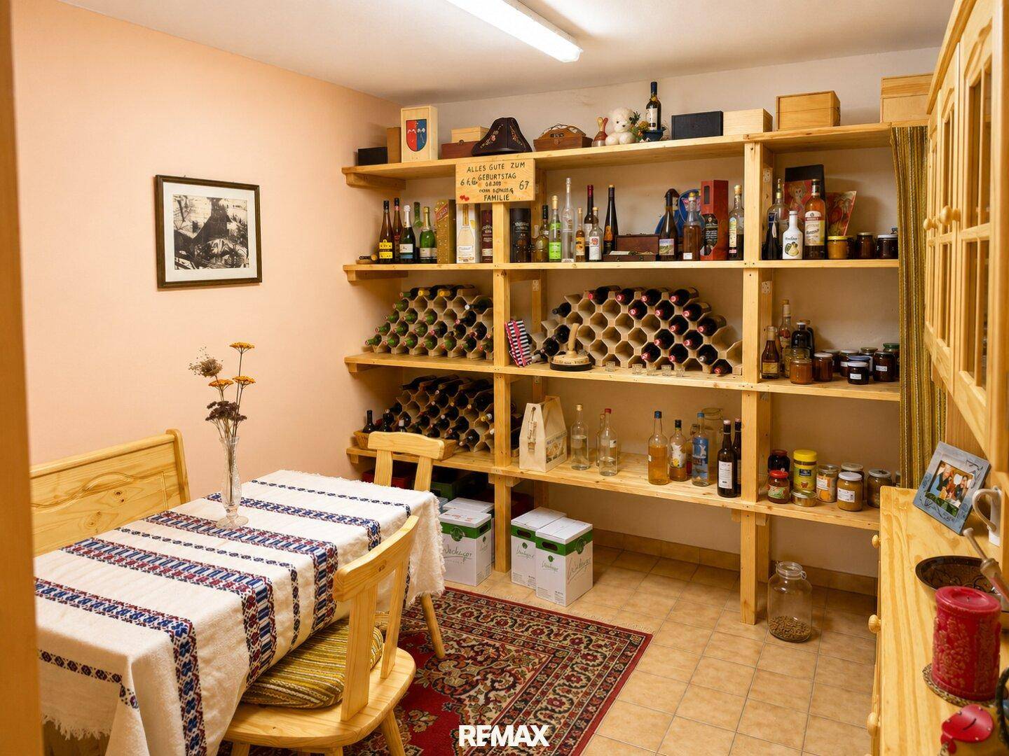 Rustikaler Weinkeller mit Holzregalen, Esstisch und umfangreicher Weinsammlung.