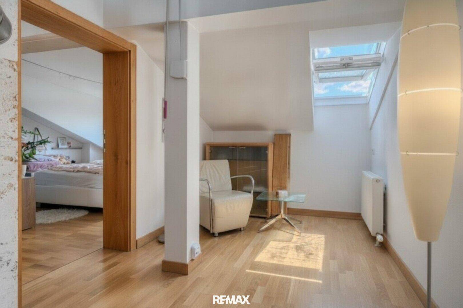 Heller Flurbereich mit Holzboden und Dachfenster, der zu einem Schlafzimmer führt.