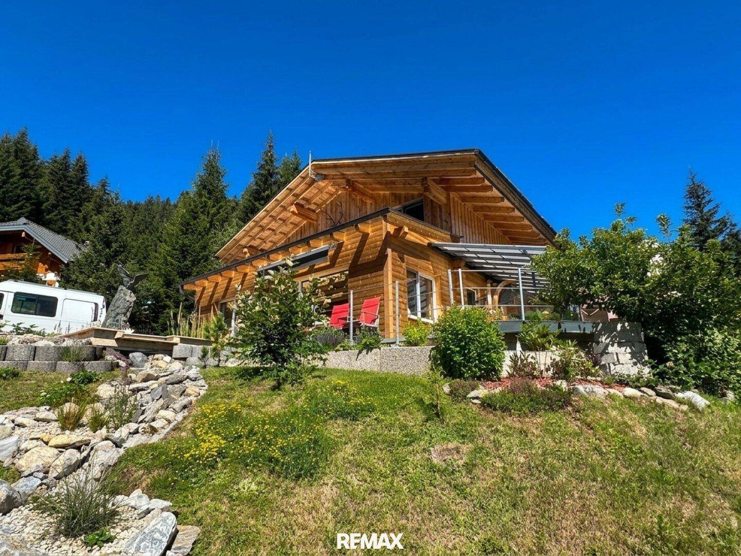 Attraktives Holzhaus im Chalet-Stil mit weitläufigem Garten und bewaldeter Umgebung.