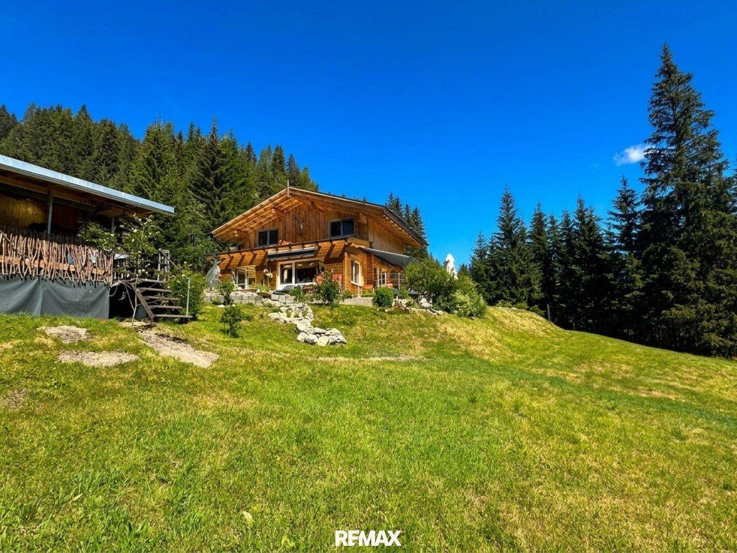 Weitläufiges Anwesen mit Haupthaus und Nebengebäude in idyllischer Berglandschaft.