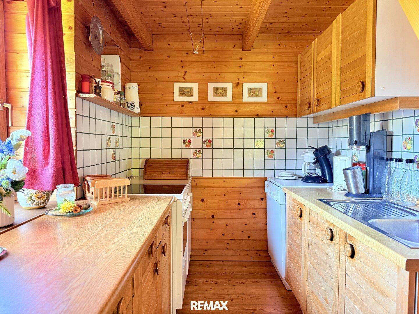Traditionelle Holzküche mit karierten Fliesen und Holzschränken, bietet eine gemütliche Kochumgebung.